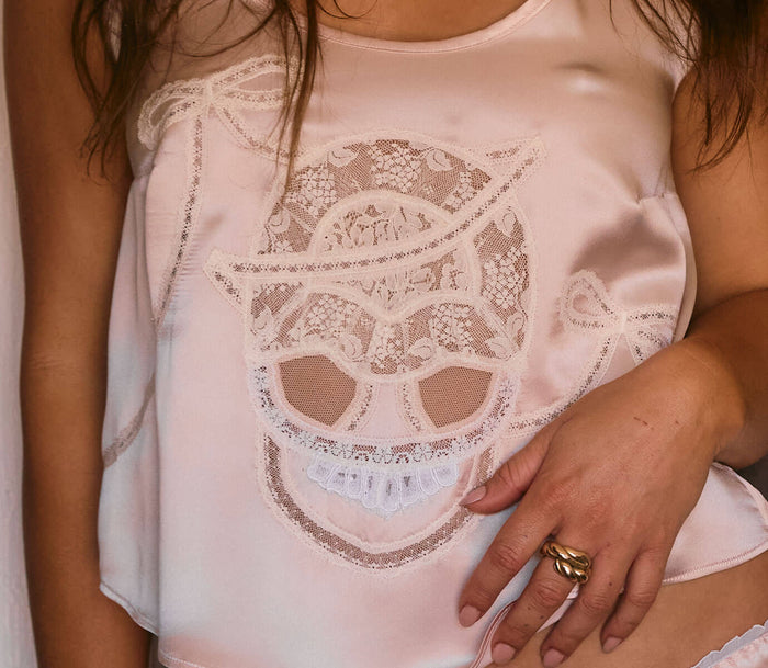 Lace skull detail with sheer skeleton Halloween gothic details in heirloom French lace on light pink pastel silk in romantic vintage style.